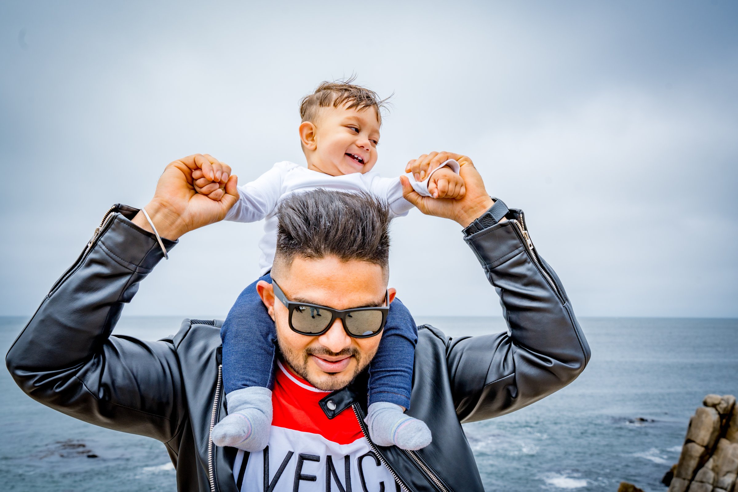 Ayaan's first birthday baby laughing on dads shoulders