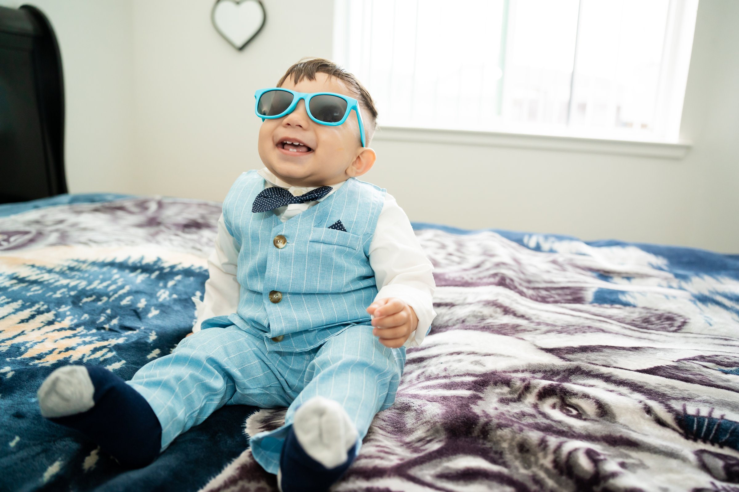 Ayaan's first birthday toddler in sunglasses window light