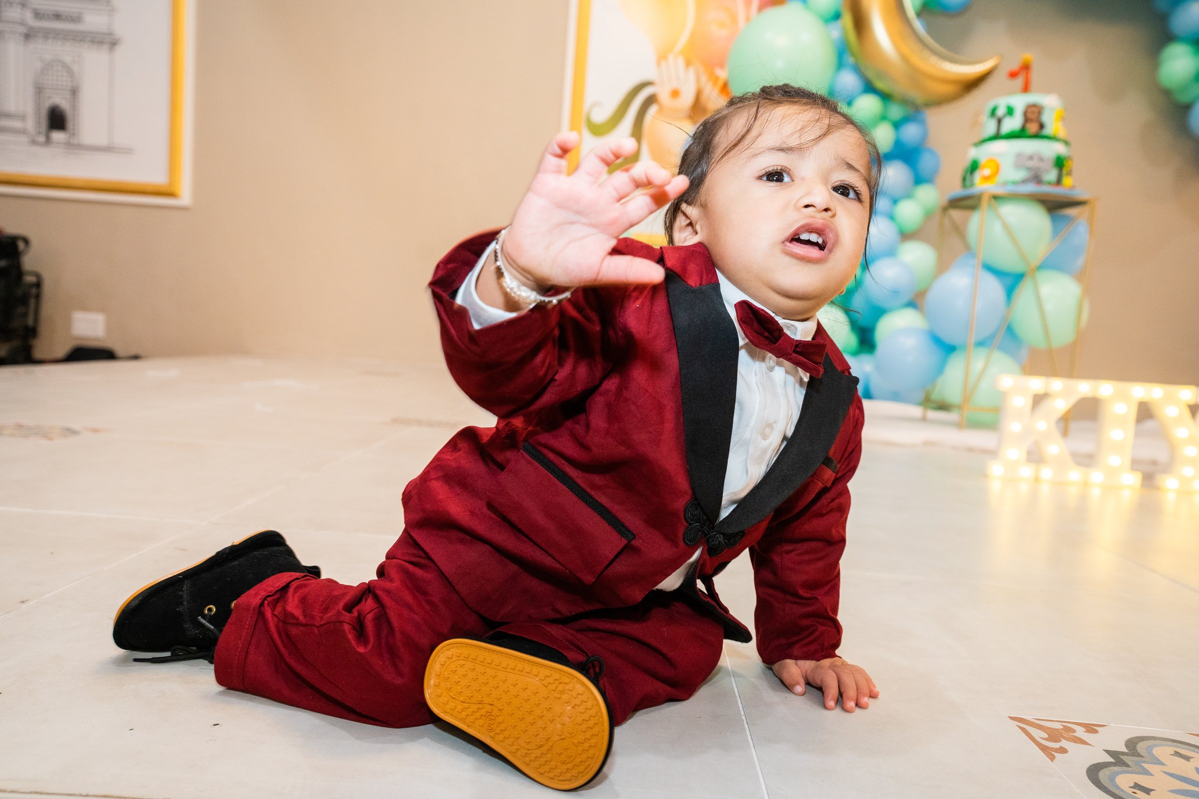 Kiyaansh 1st birthday crawling toward camera past cake