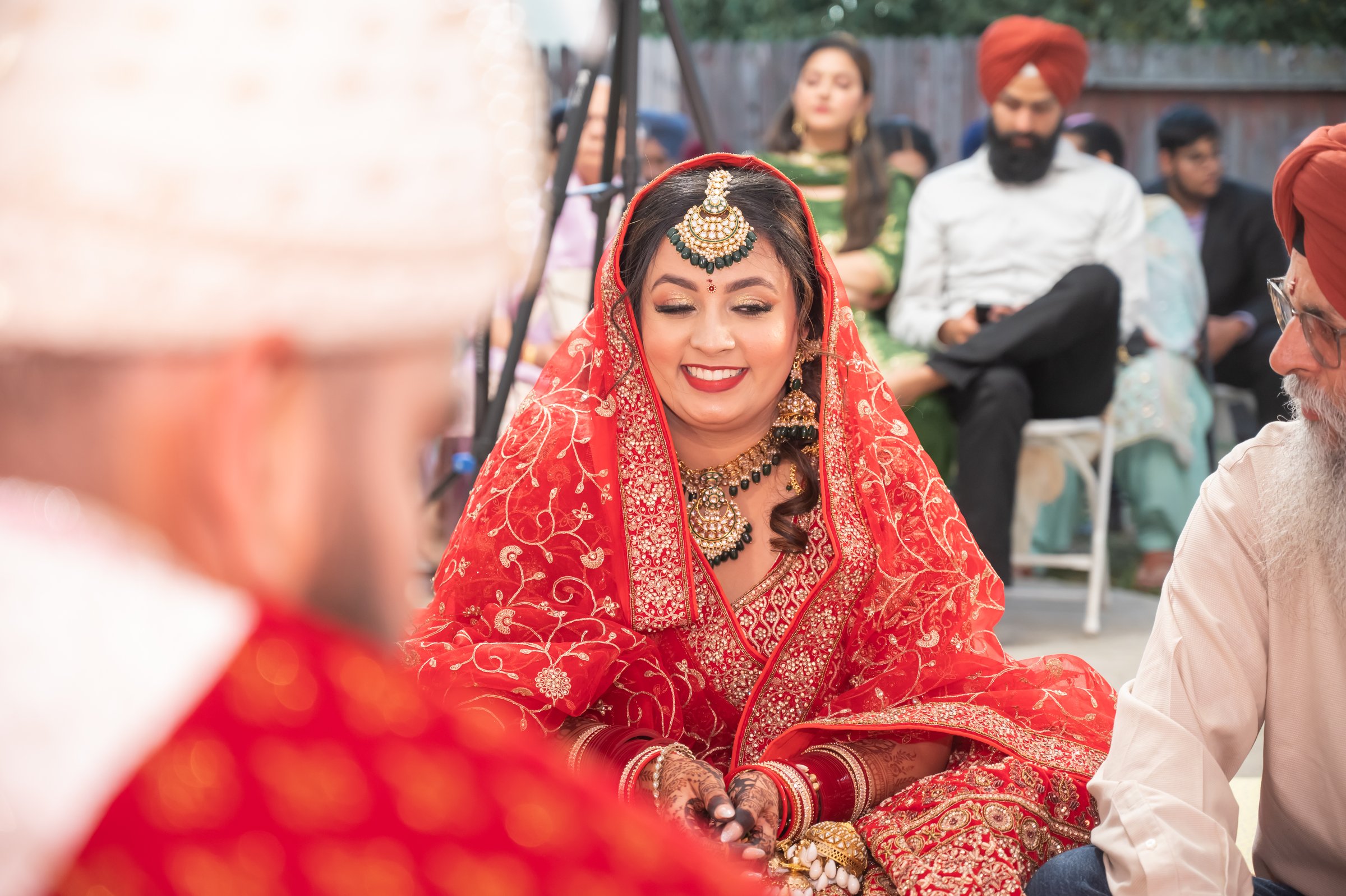 Harpreetandarun bride through red foreground blur