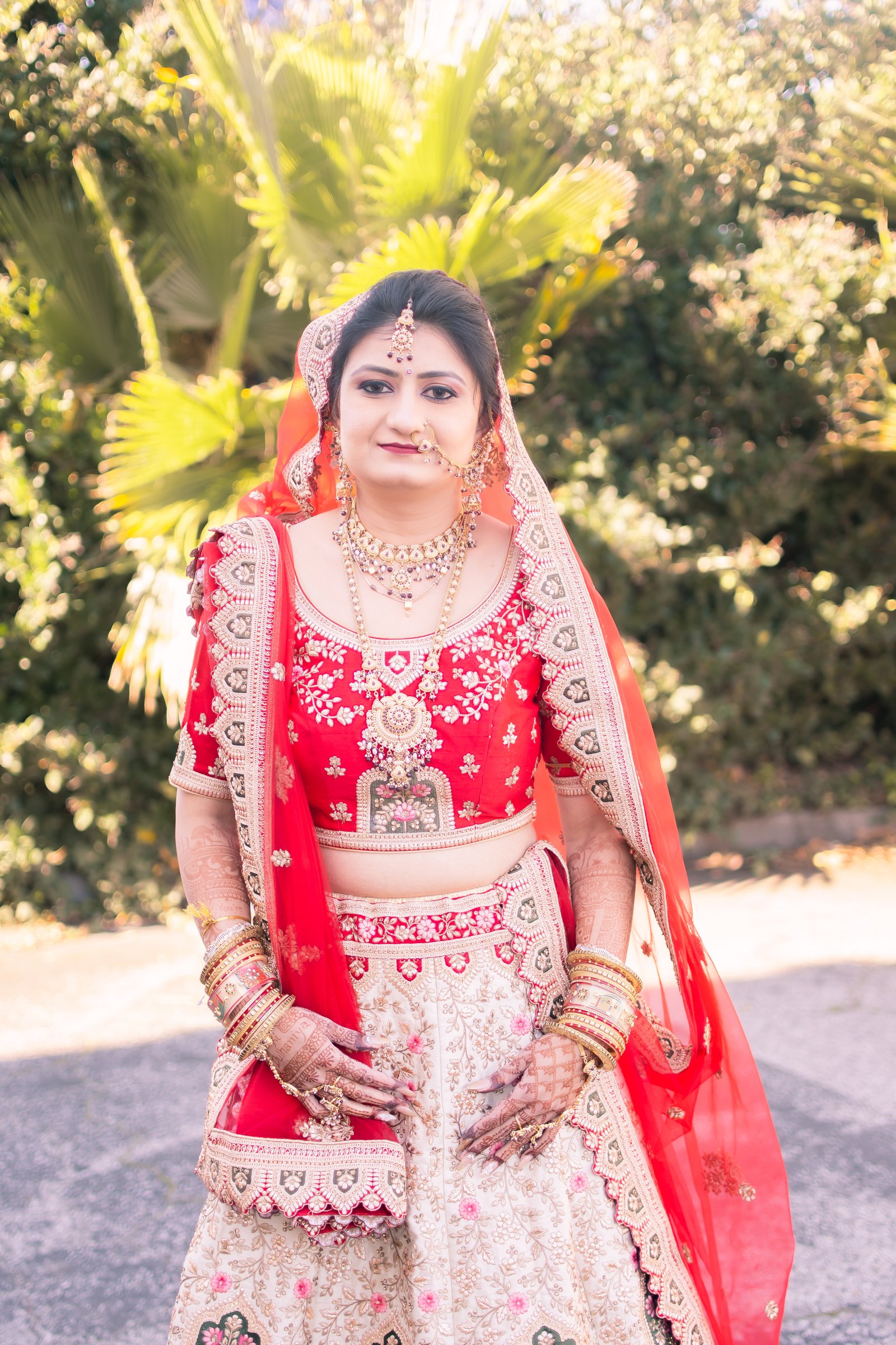 A backlit bride in a red dupatta